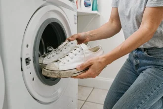 Femme plaçant des baskets blanches dans un lave-linge sans filet de lavage