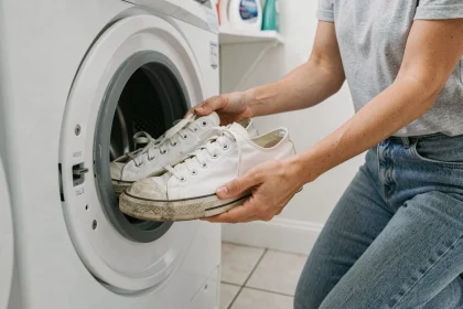 Femme plaçant des baskets blanches dans un lave-linge sans filet de lavage